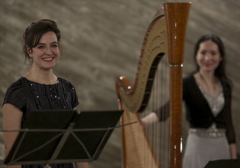 Zwei Musikerinnen nach einer Aufführung von „Lieder in Bildern“. Zwischen ihnen steht die Harfe.